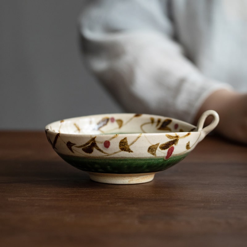 Hand-painted green-glazed ceramic bowl with looped handle