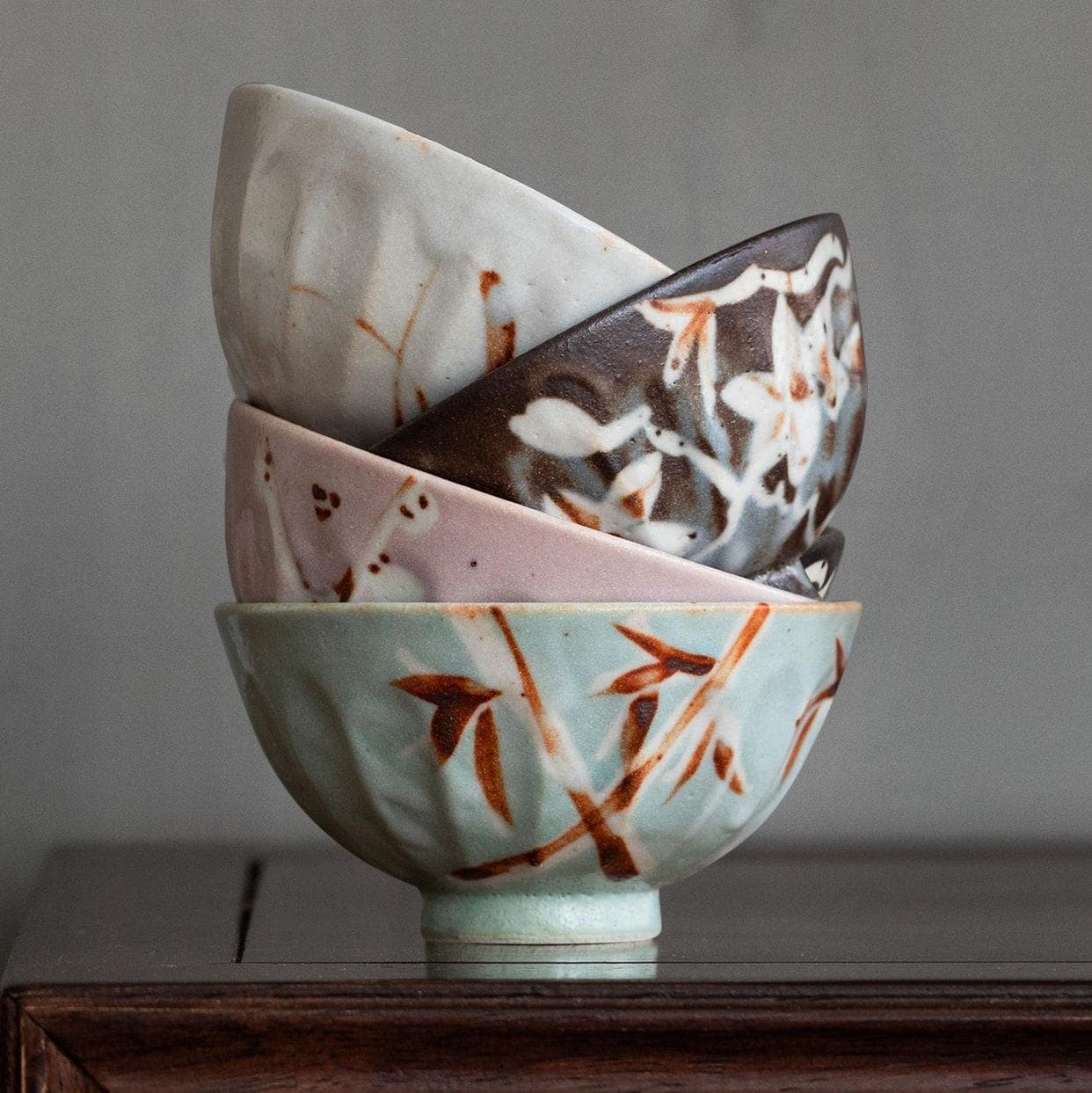 Four beautifully crafted ceramic bowls on a wooden table.