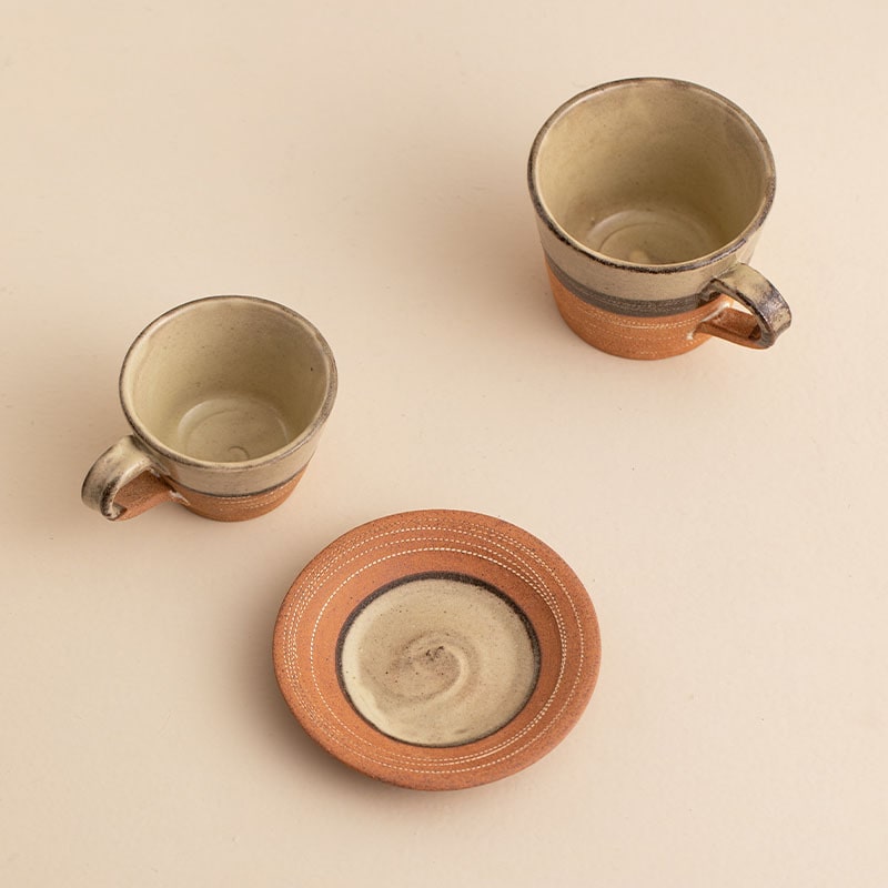 Close-up of earthy-toned coffee cup with hand-etched patterns.