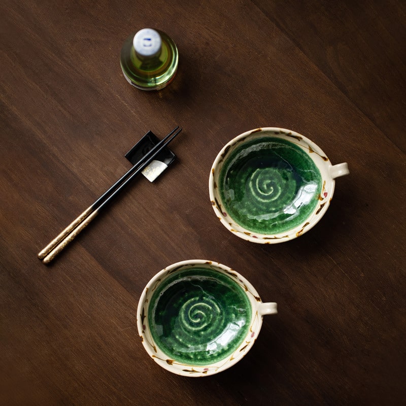 Bottom view of green floral bowl showing artisan stamp