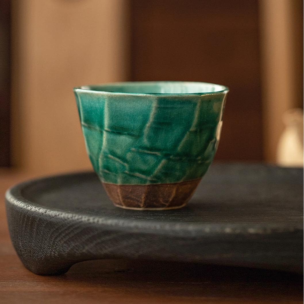 Single green ceramic cup showcasing intricate craftsmanship