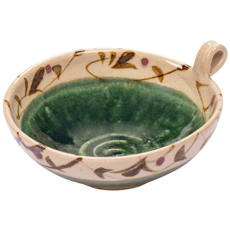 Pair of green ceramic bowls with floral interior design on a table