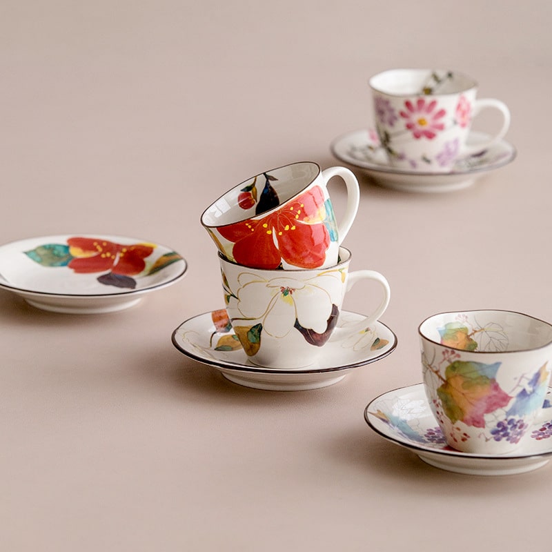 Stack of colorful Japanese floral mugs with hand-painted details.