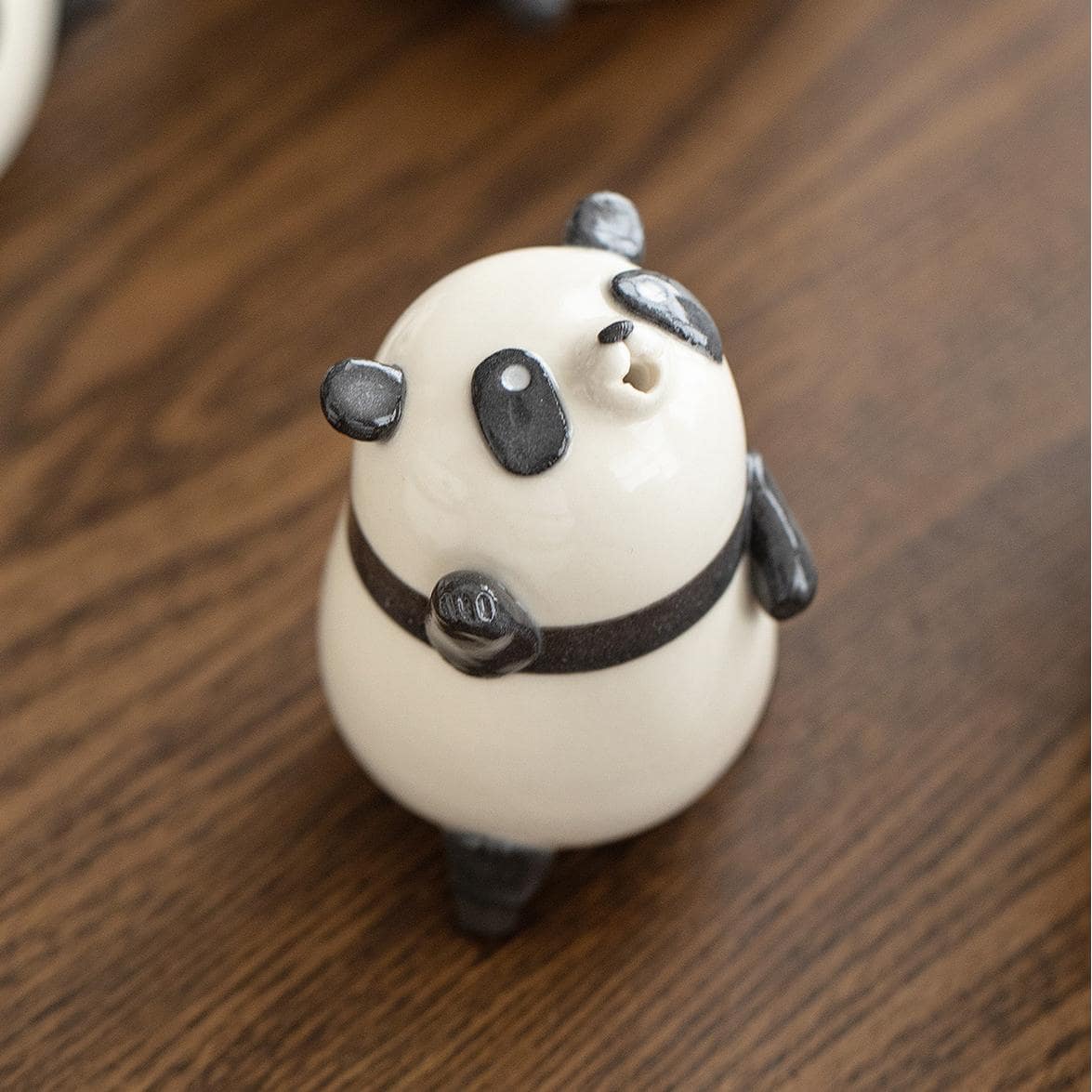 Pair of panda-shaped ceramic coffee cups on a wooden surface