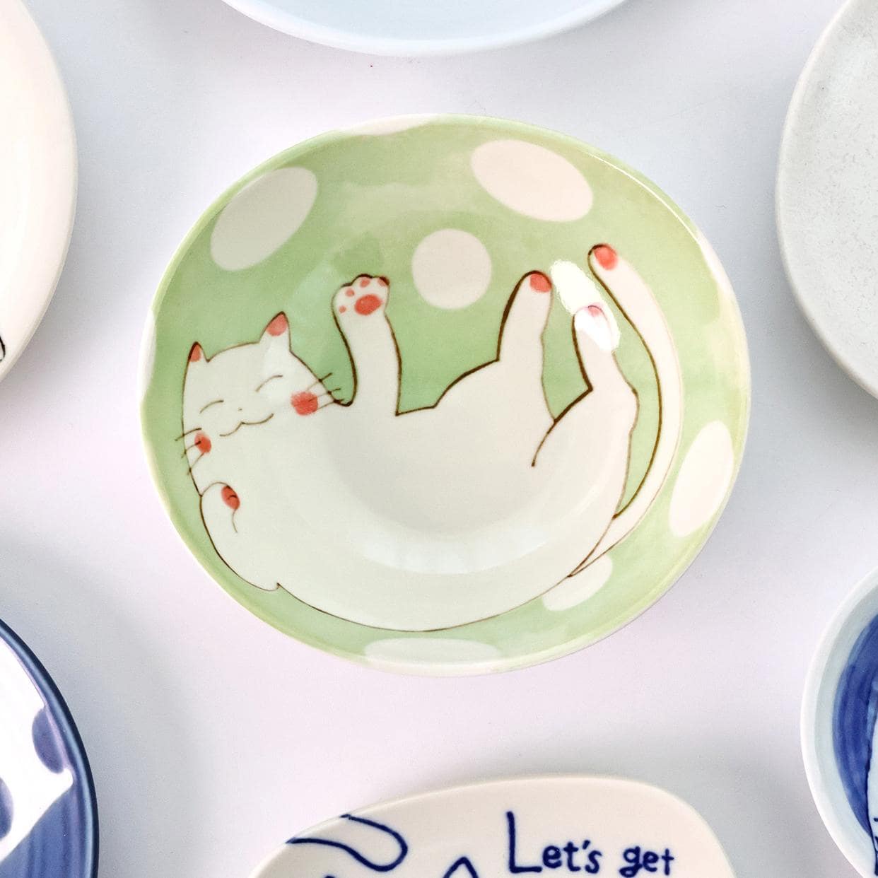 Handcrafted ceramic dipping bowl featuring a winking cat illustration