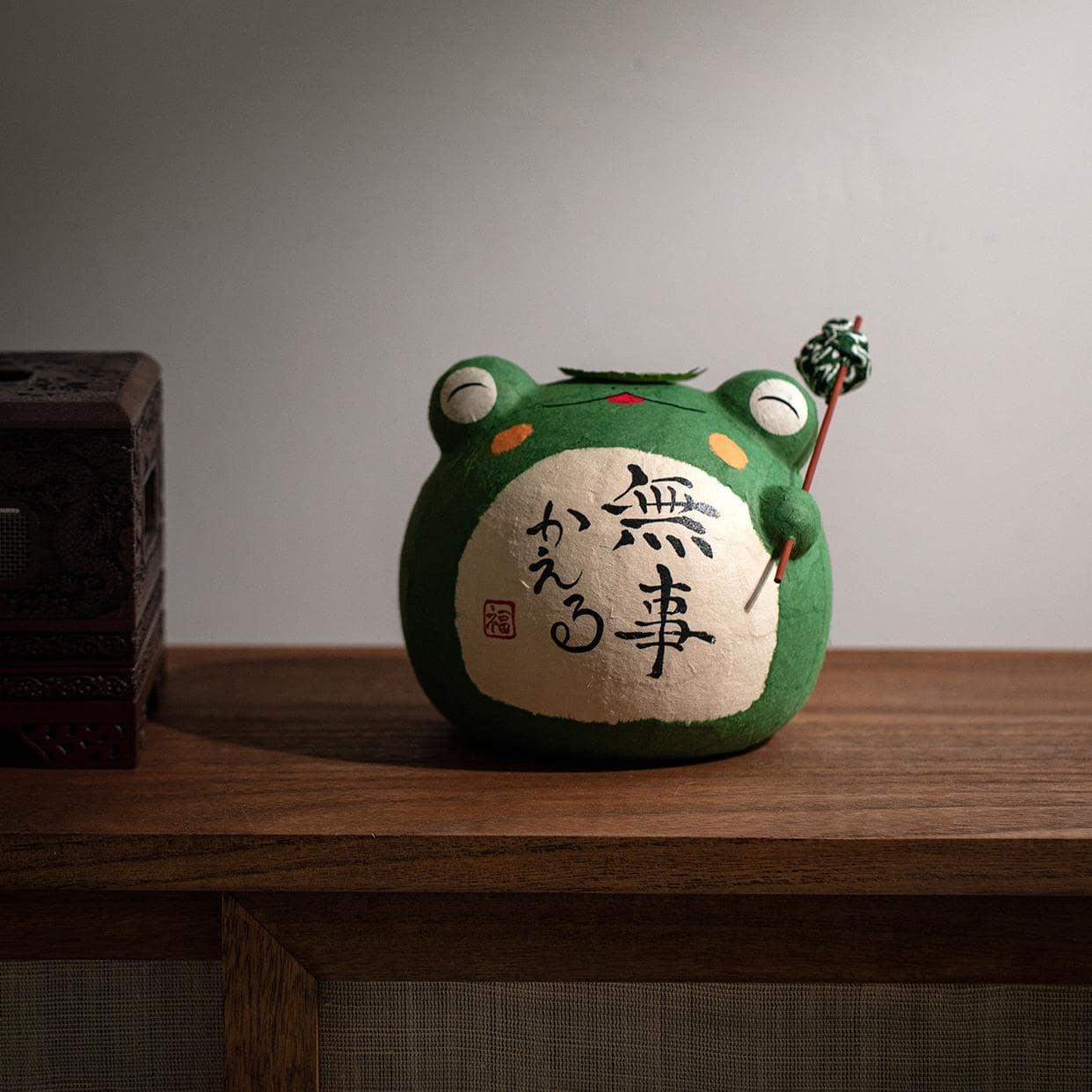 Japanese ceramic frog ornament with lotus leaf and inscriptions.