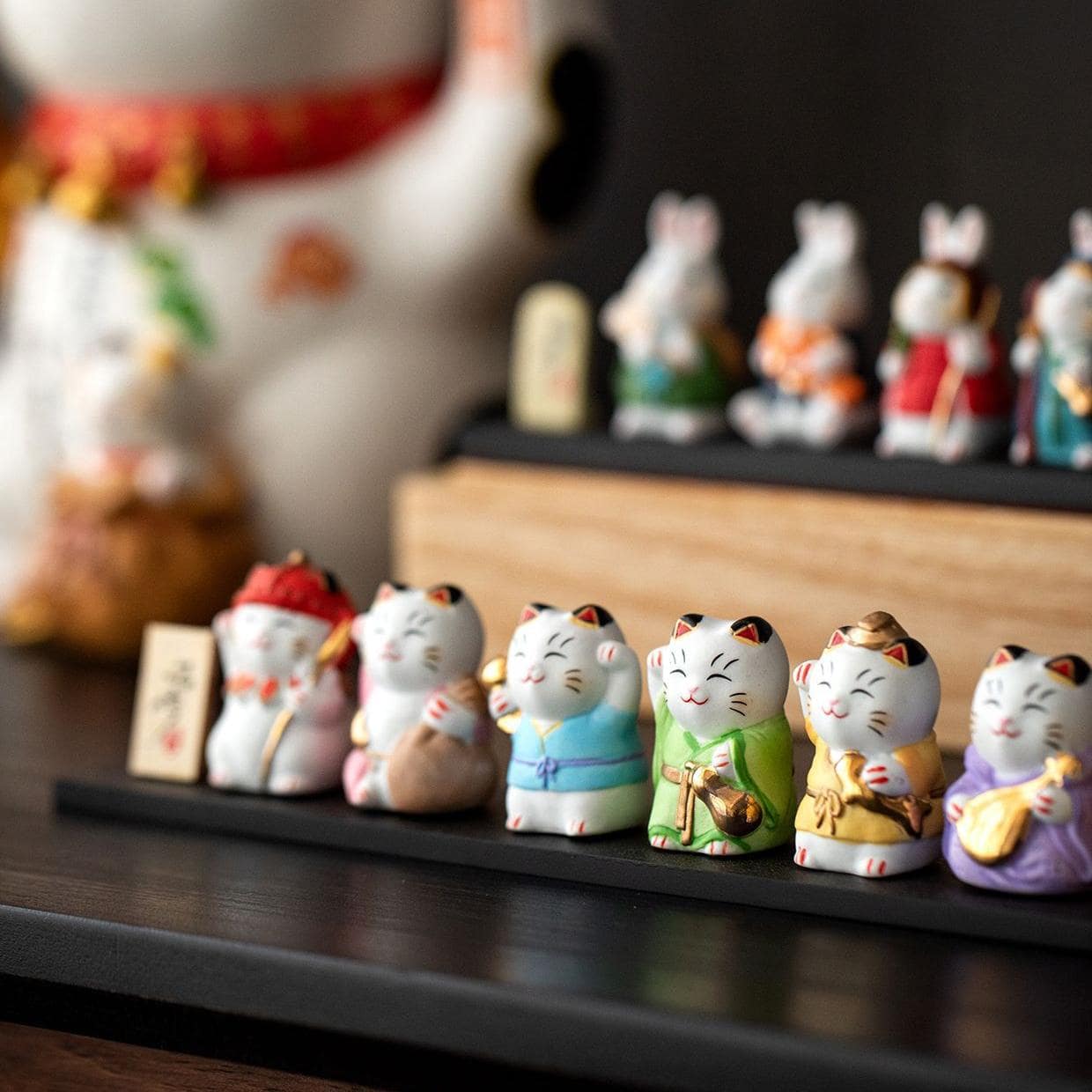 Close-up of red-dressed ceramic lucky cat figurine