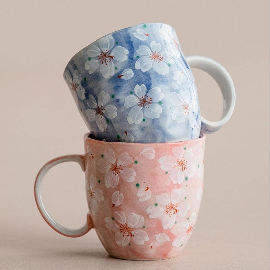 Pair of cherry blossom mugs in pink and blue pastel hues.