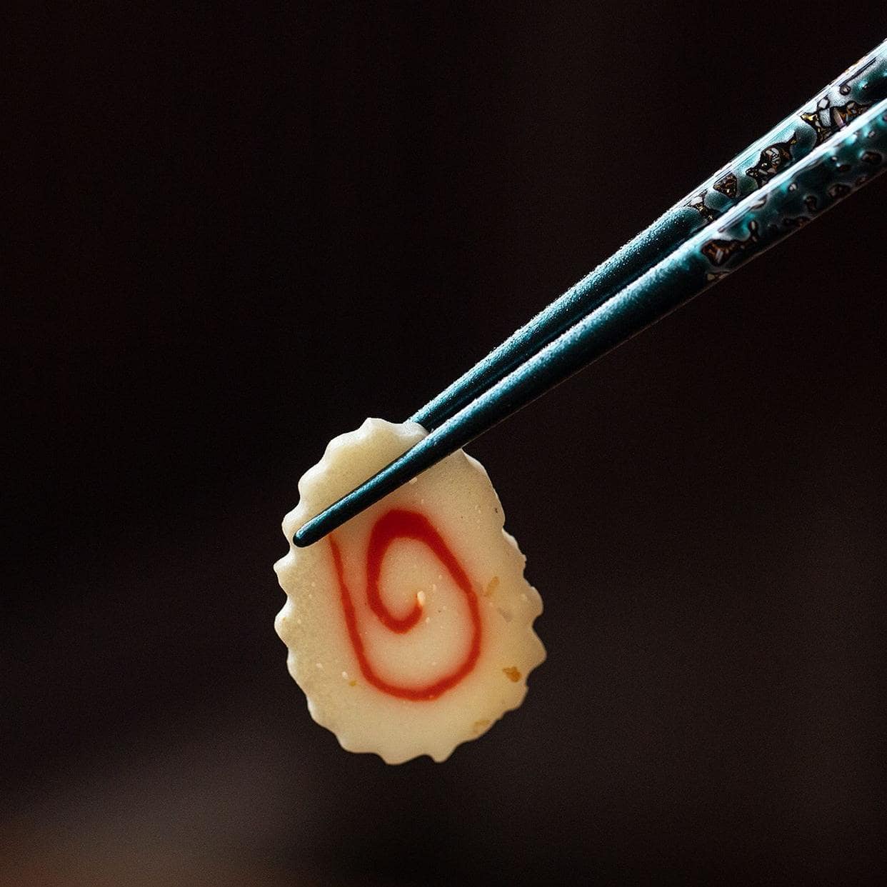 Close-up of non-slip pointed chopsticks in red and blue designs.