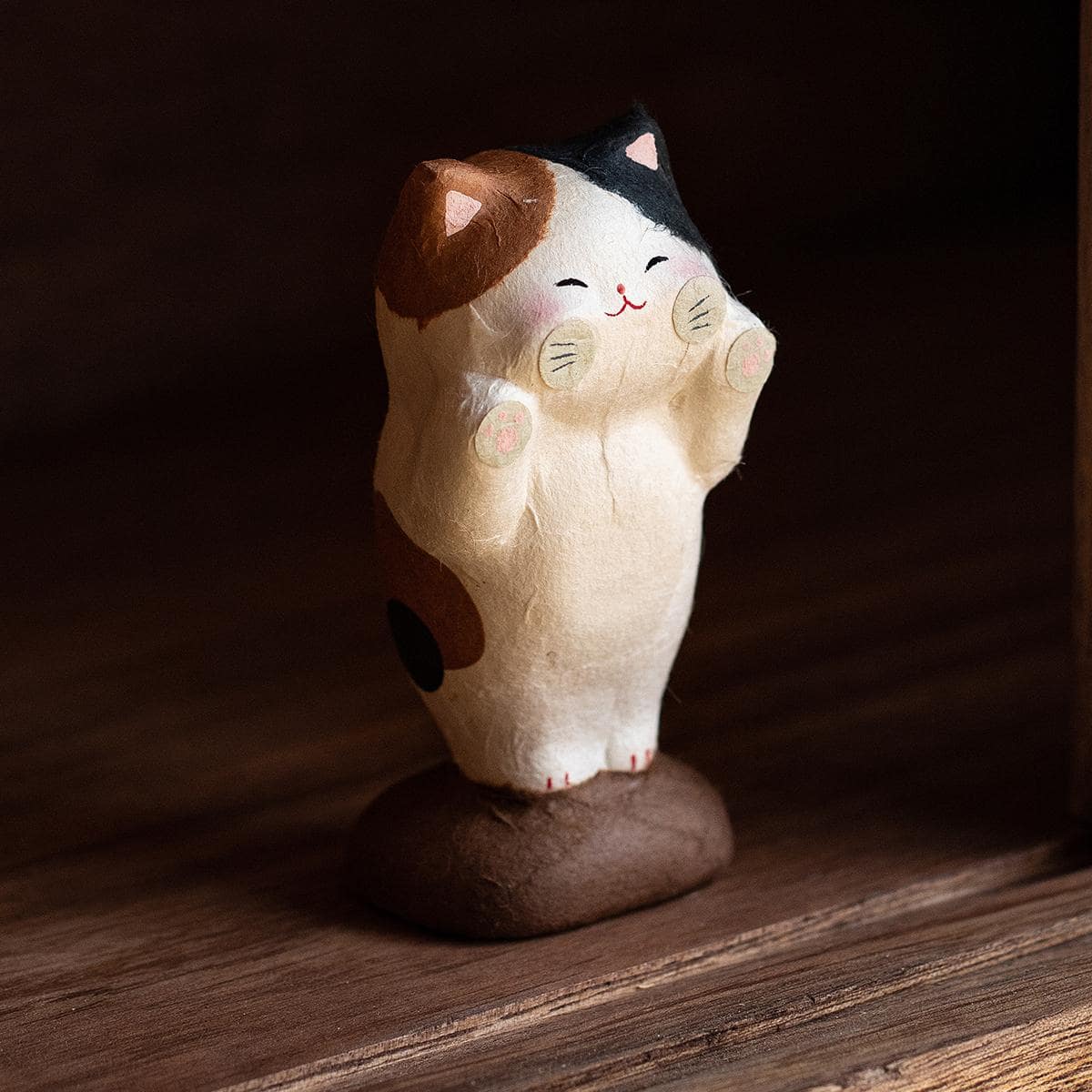 Adorable ceramic cat decoration on a wooden table