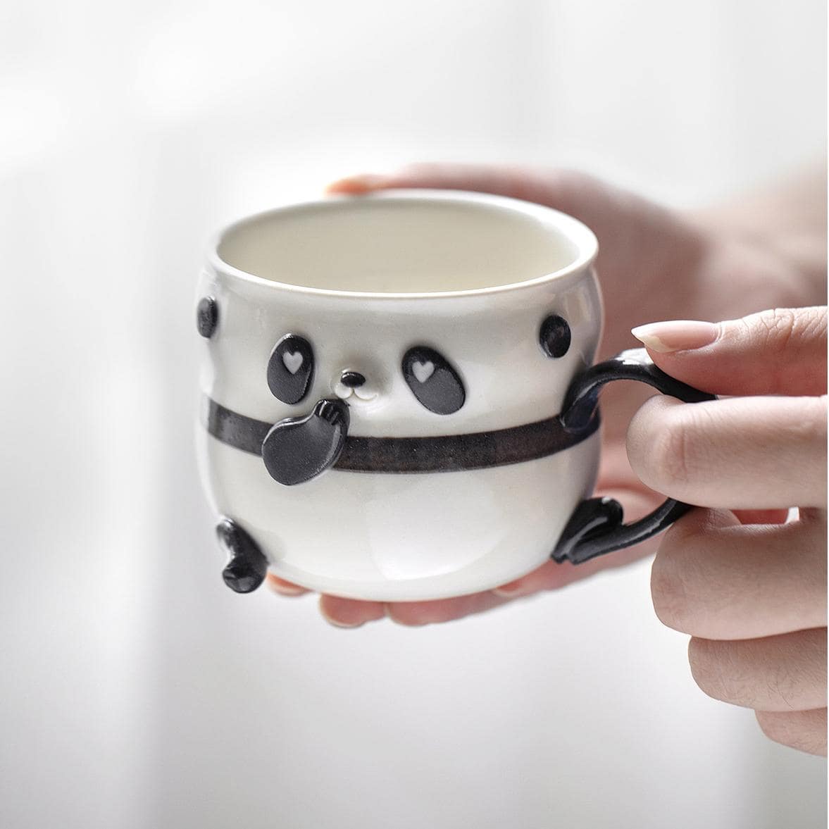 Collection of panda-themed ceramic cups displayed on a table