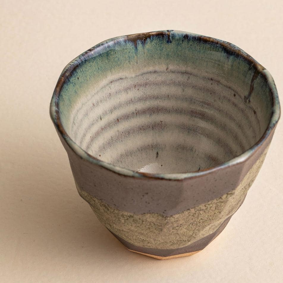 Single green ceramic cup showcasing intricate craftsmanship