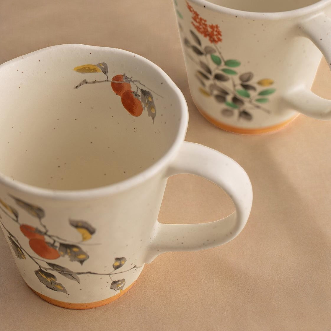 Ceramic mugs with floral patterns displayed on a wooden gift box