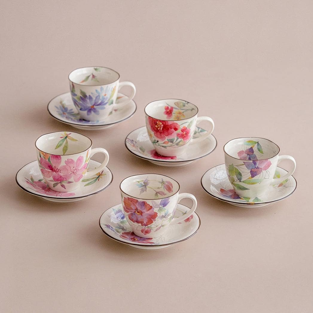 Stack of colorful Japanese floral mugs with hand-painted details.