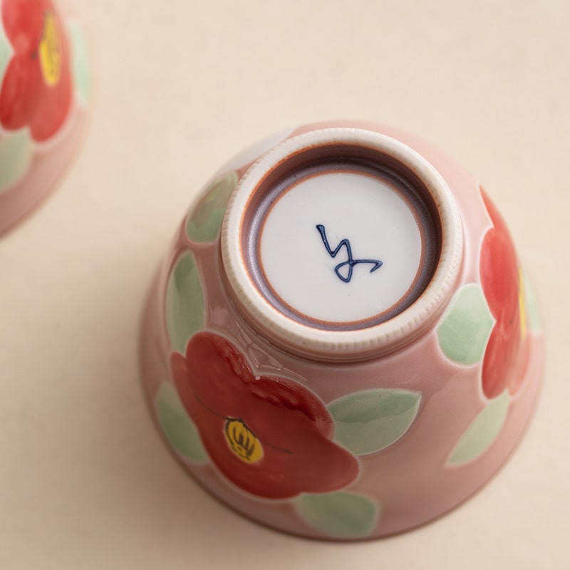 Close-up of hand-painted floral details on a ceramic tea cup.