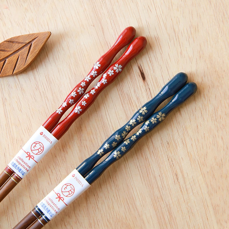 Close-up of sakura-themed lacquered chopsticks in red and blue