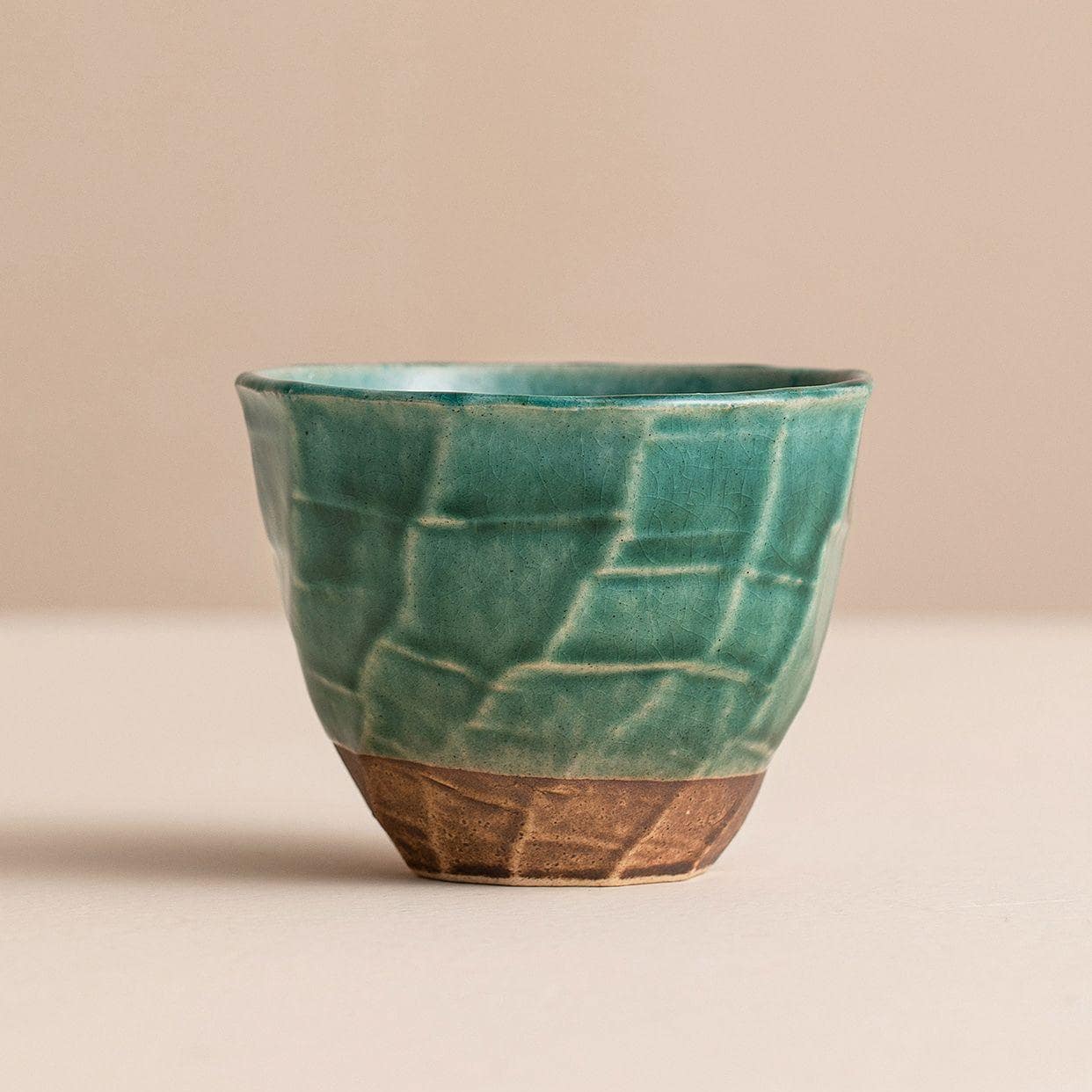 Single green ceramic cup showcasing intricate craftsmanship