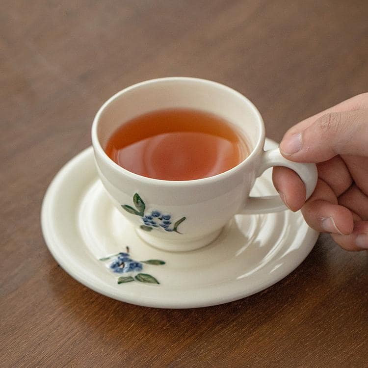 Hand-painted ceramic tea cup and saucer displayed beautifully.