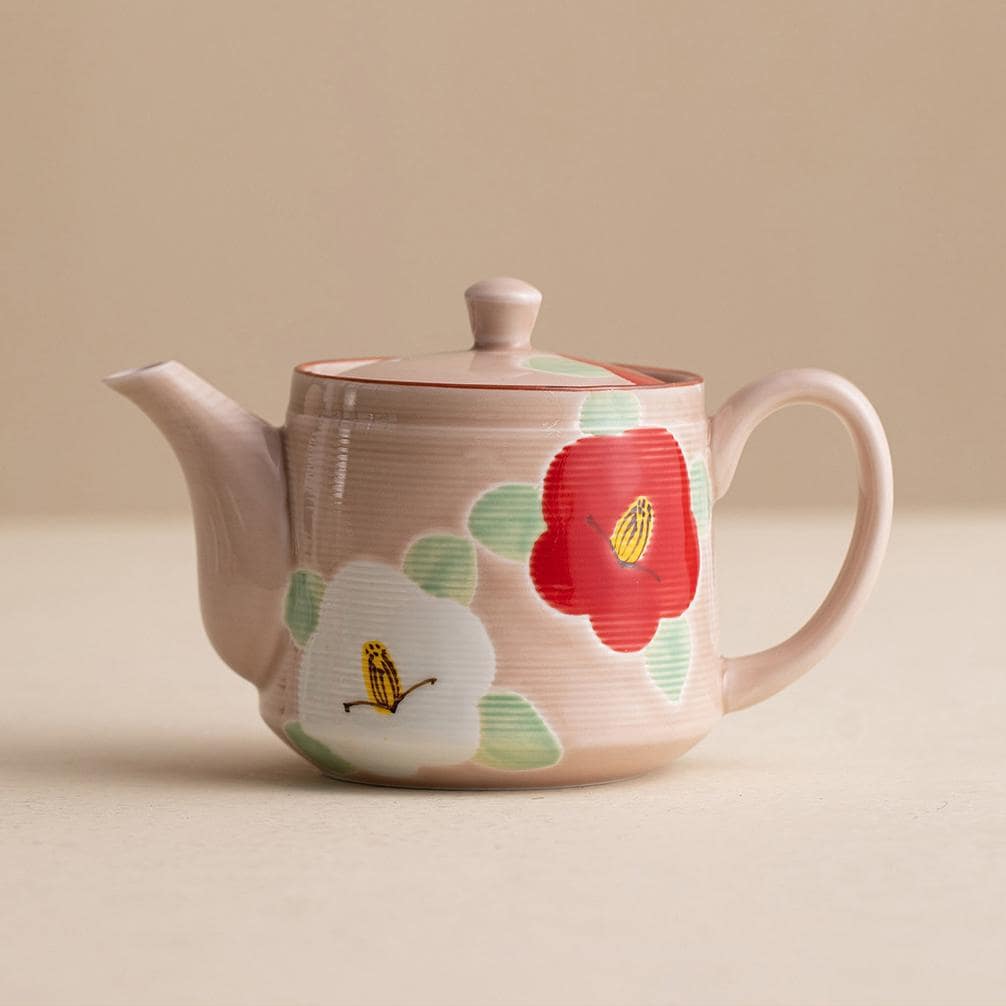 Elegant ceramic teapot and matching cups with floral designs.