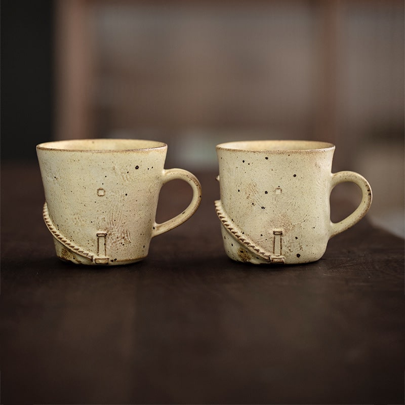 Rustic ceramic cup with speckled design and hand-carved details.