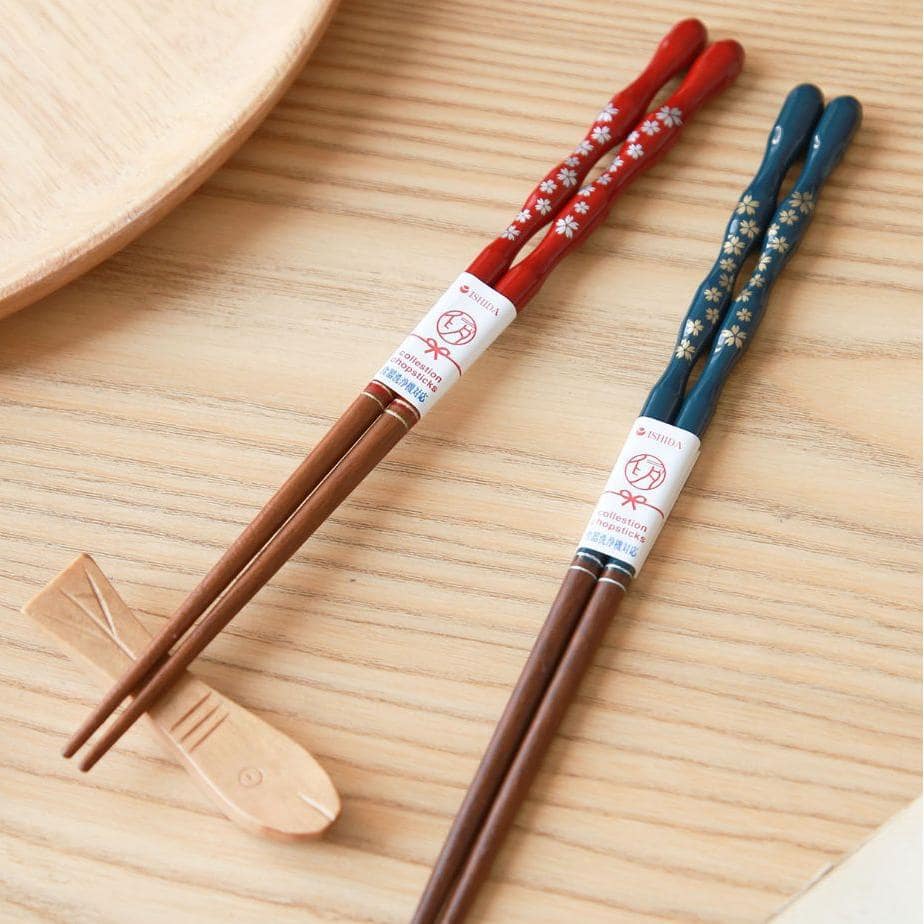 Blue and red lacquered chopsticks displayed on wooden surface