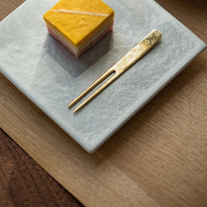 Elegant fork piercing a slice of colorful layered cake