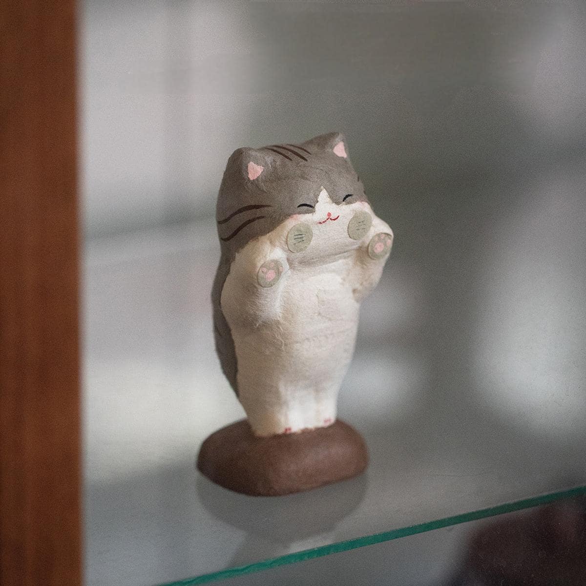 Whimsical cat figurine displayed on a windowsill