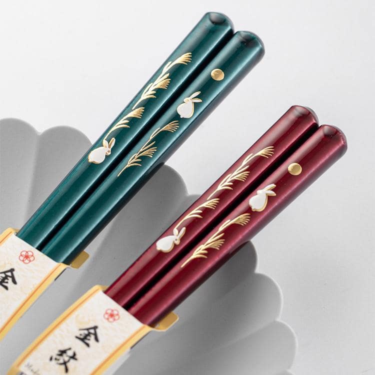 Close-up of rabbit and wheat design on handcrafted chopsticks.