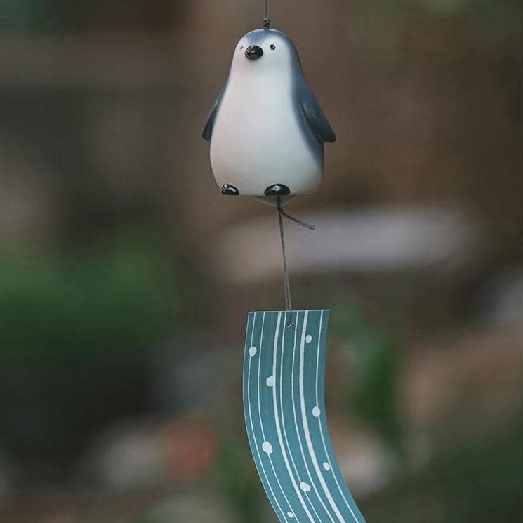 Pair of ceramic birds atop a Pharmacist Kiln wind chime.