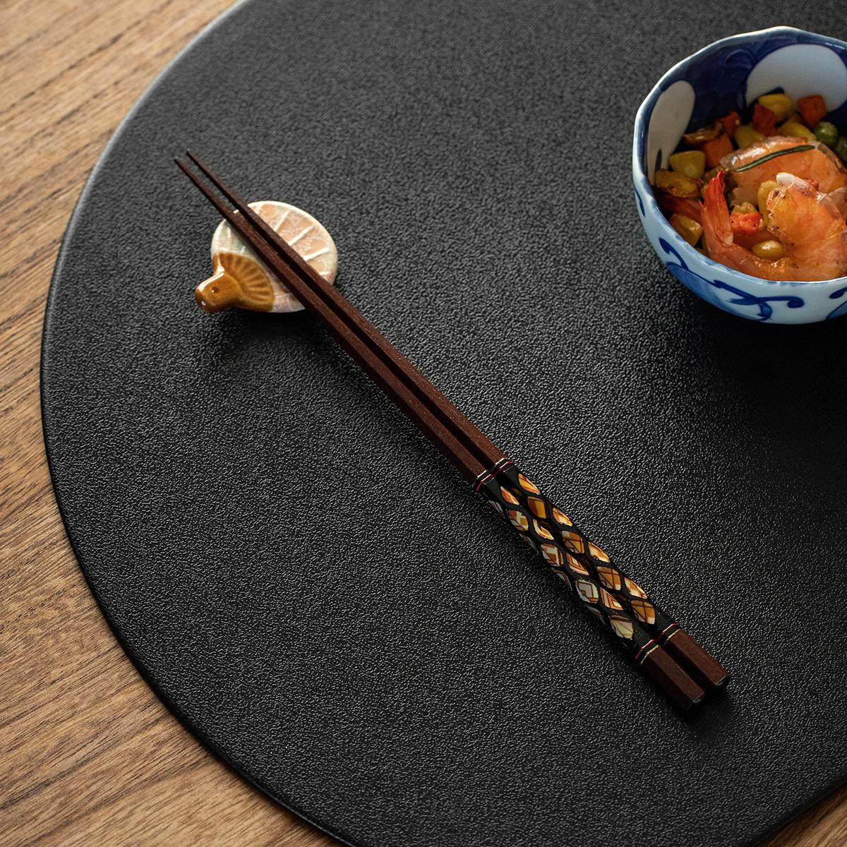 Authentic Japanese wooden chopsticks resting next to a rice bowl.