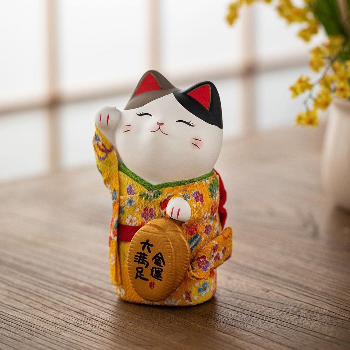 Adorable prosperity cat figurines displayed on a shelf.