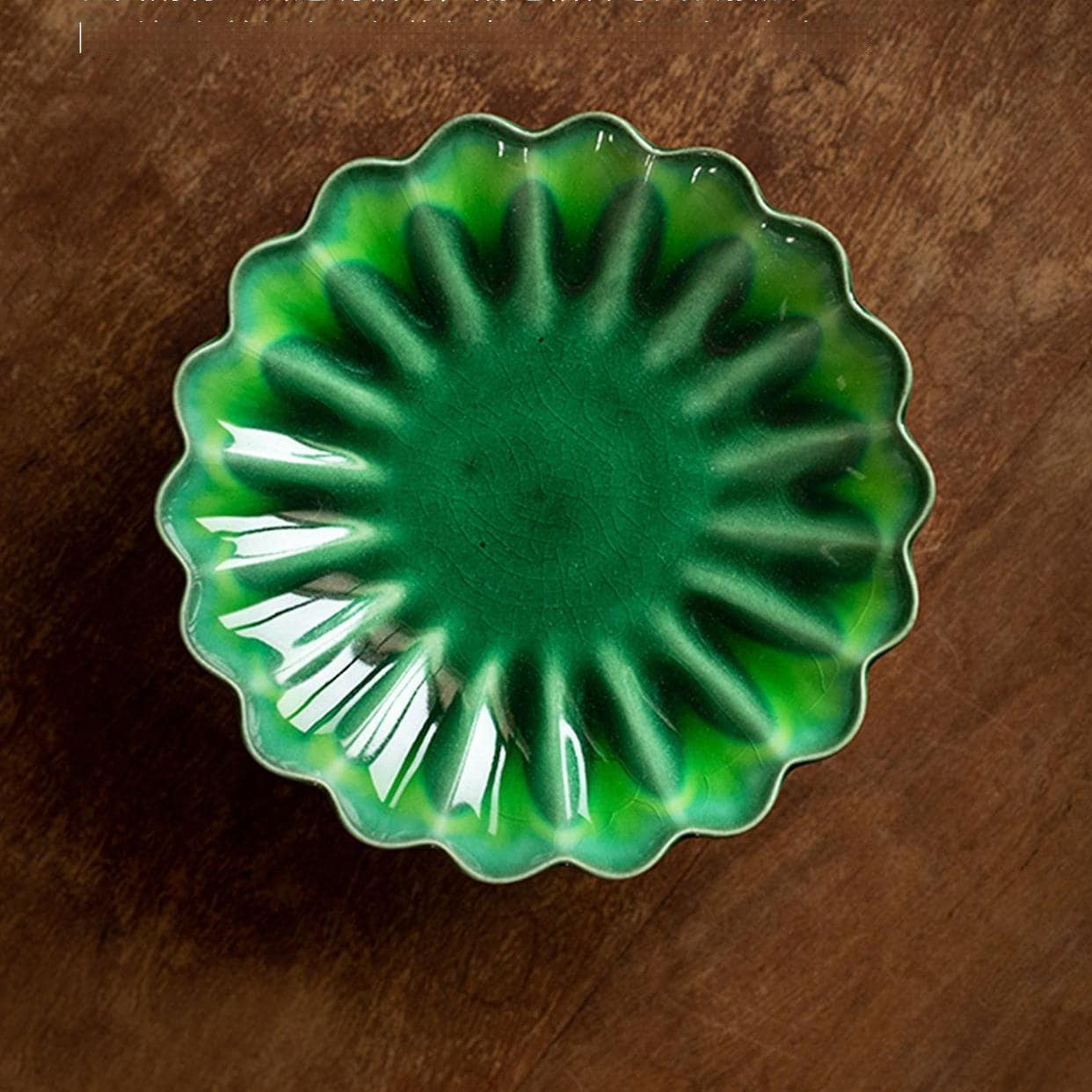 Artistic Japanese chrysanthemum-style ceramic tableware on a wooden table.