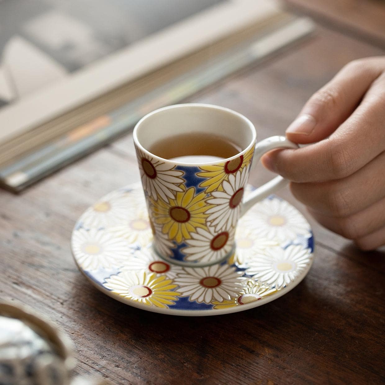 Artistic floral porcelain cup and matching saucer