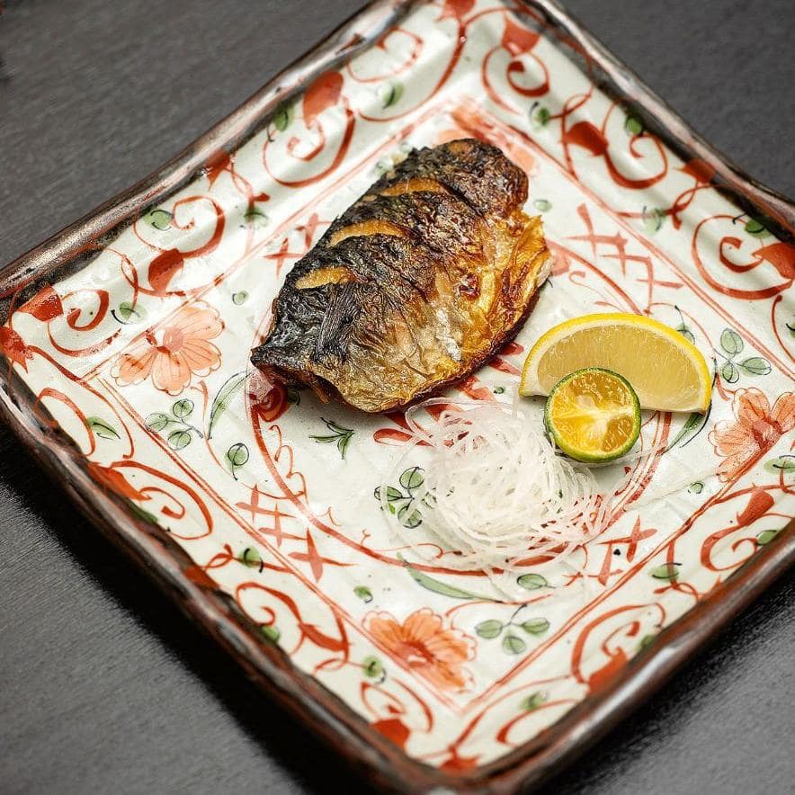 Square Japanese ceramic sushi plate on a wooden table.