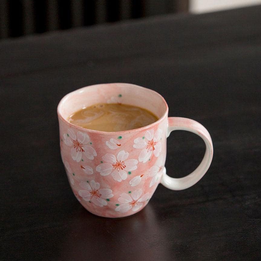 Base of the blue ceramic coffee cup with cherry blossom design.