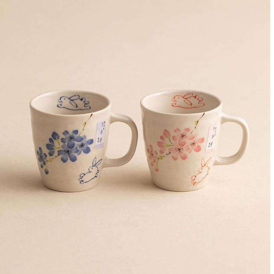 Close-up of hand-painted floral ceramic mugs on a table