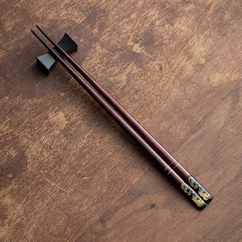 Close-up of elegant wooden chopsticks with gold patterns