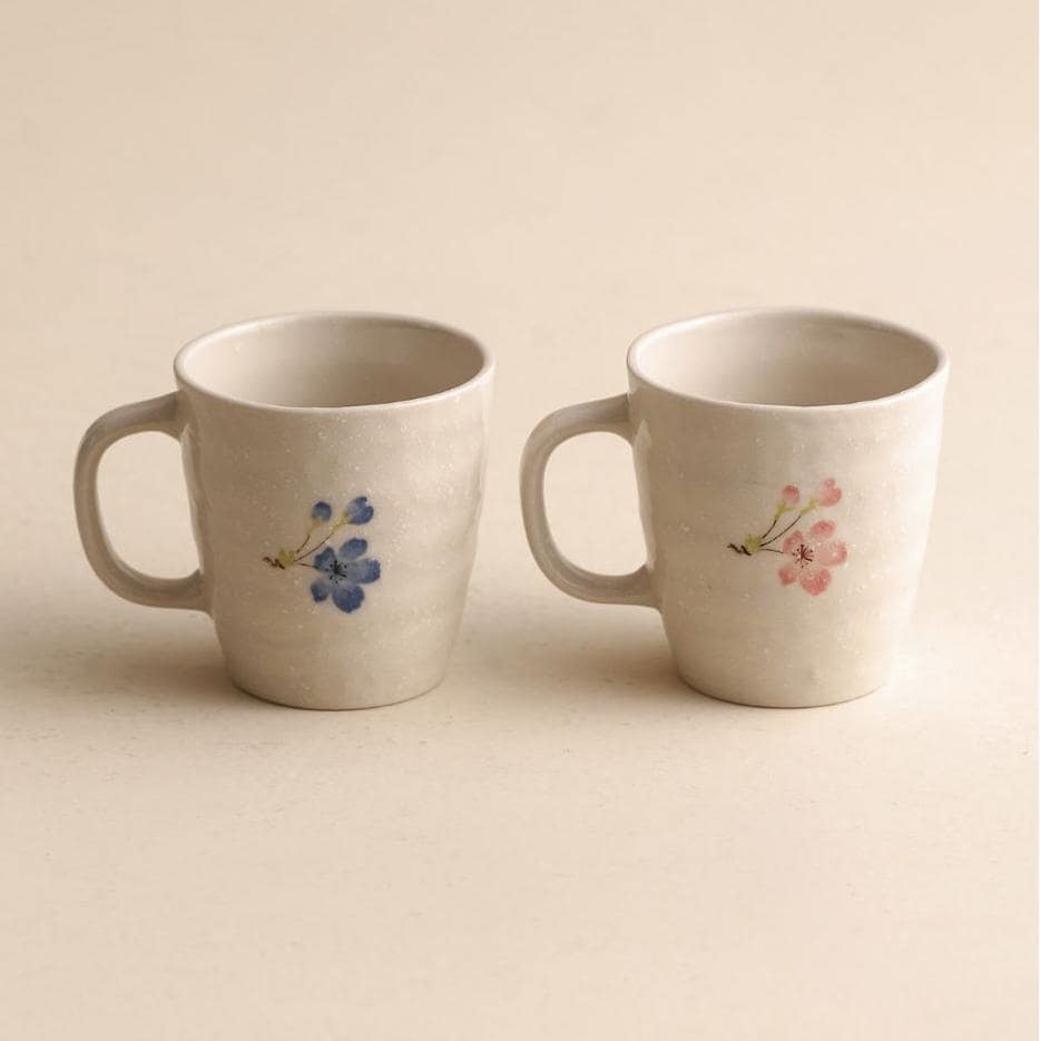 Ceramic mugs with floral patterns displayed on a wooden gift box