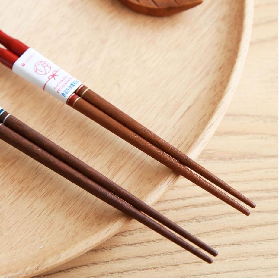 Pair of cherry blossom design chopsticks with wooden rest