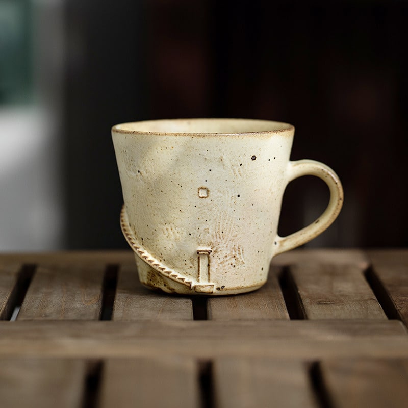 Speckled ceramic tea cup with ergonomic handle.