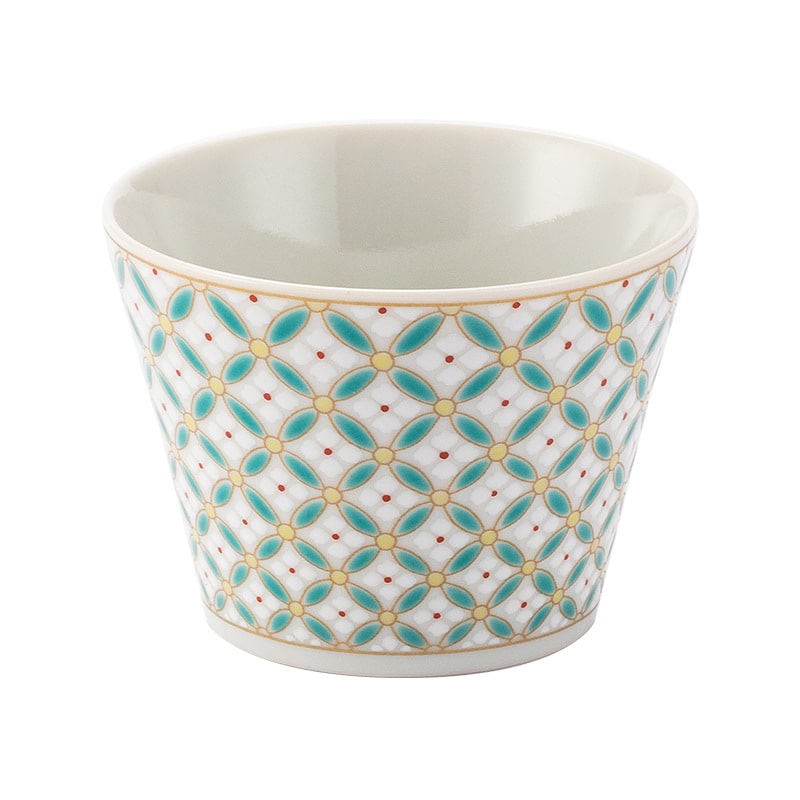 Modern ceramic cup with a colorful geometric pattern, displayed on a table.