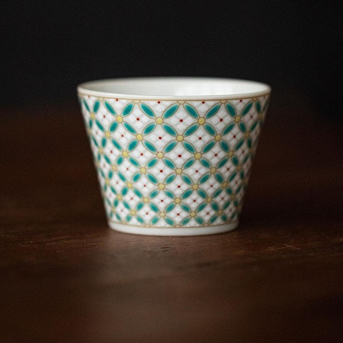 Bottom view of the patterned ceramic cup and saucer on a neutral background.