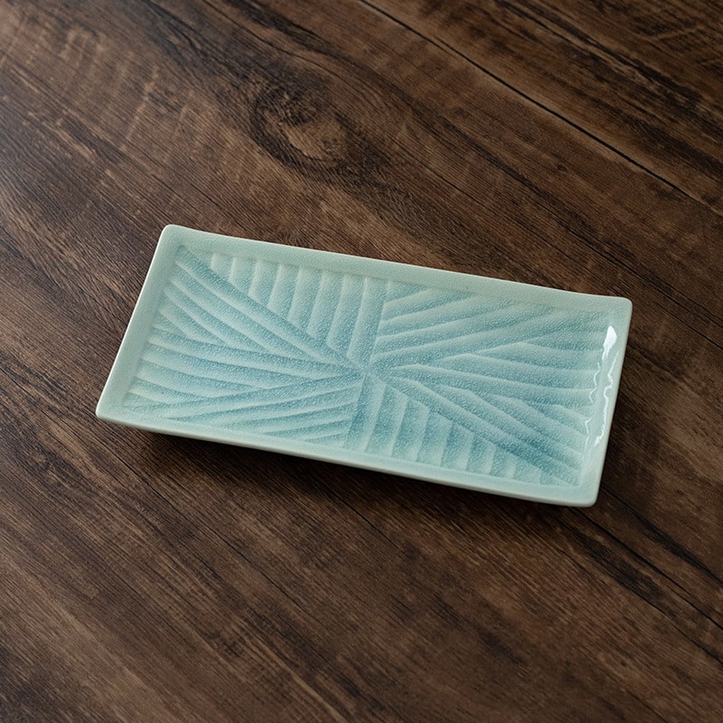 Rectangular ceramic plate with textured surface on wooden table