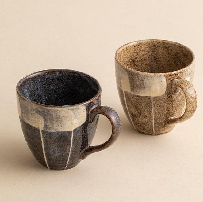 Close-up of hand-painted floral ceramic mugs on a table