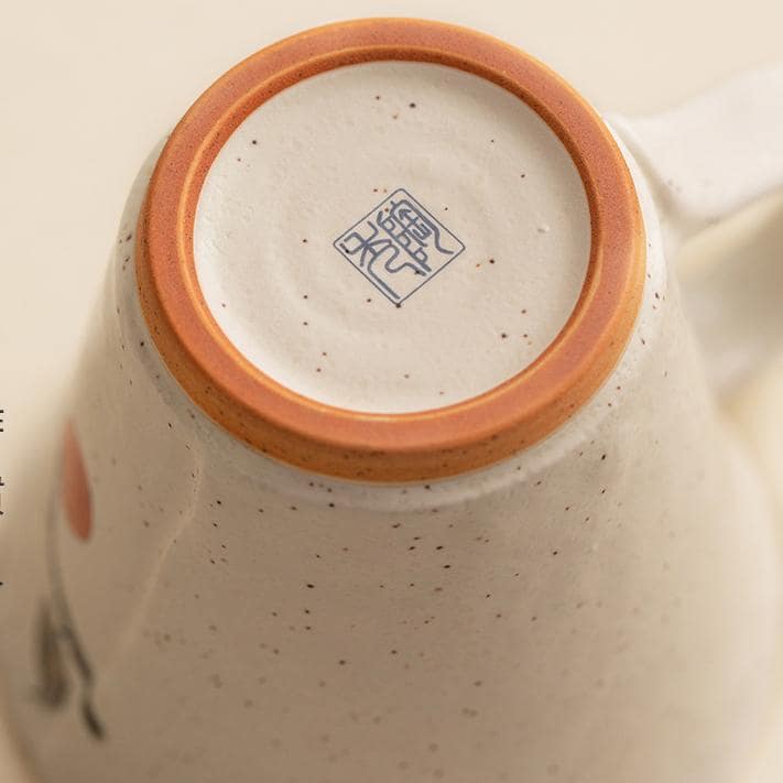 Close-up of hand-painted floral ceramic mugs on a table