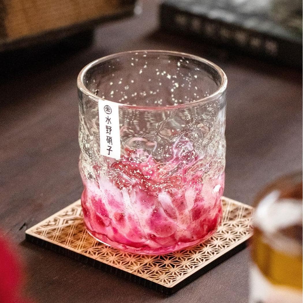 Artistic cherry blossom whiskey glass with textured design.