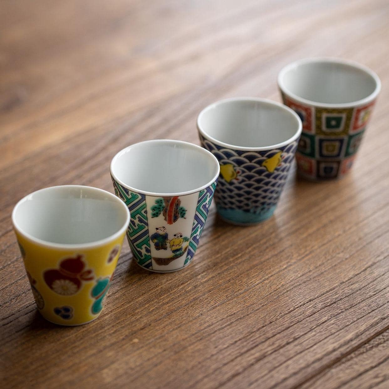 Hand holding a Japanese porcelain cup with intricate details