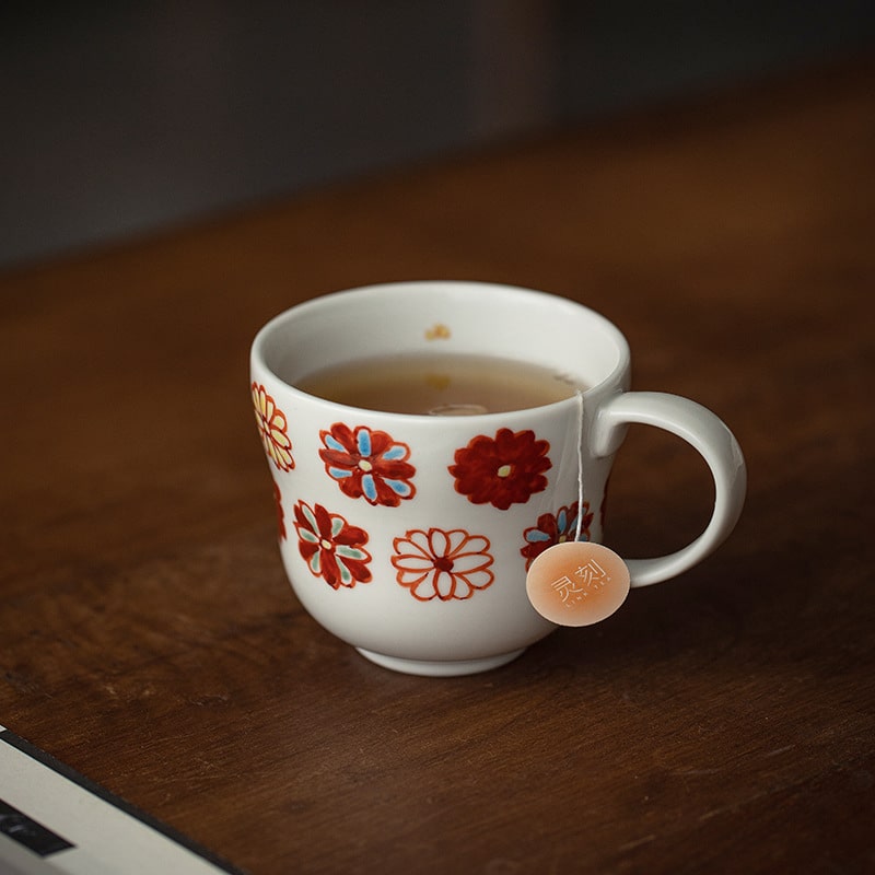 Hand holding a ceramic mug with a blue floral design