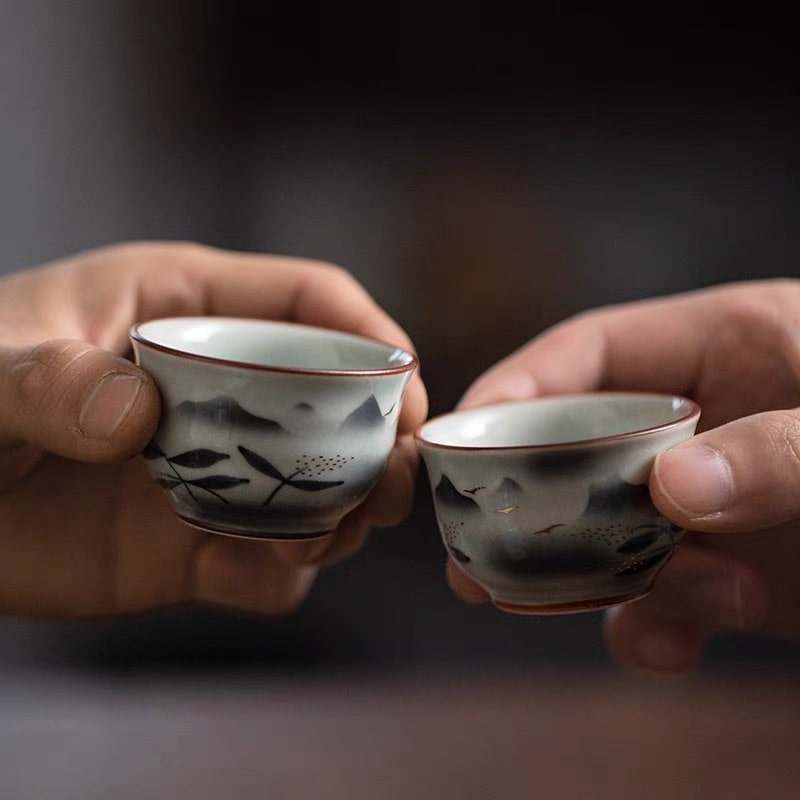 Elegant soft green sake bottles and matching cups on a wooden table.
