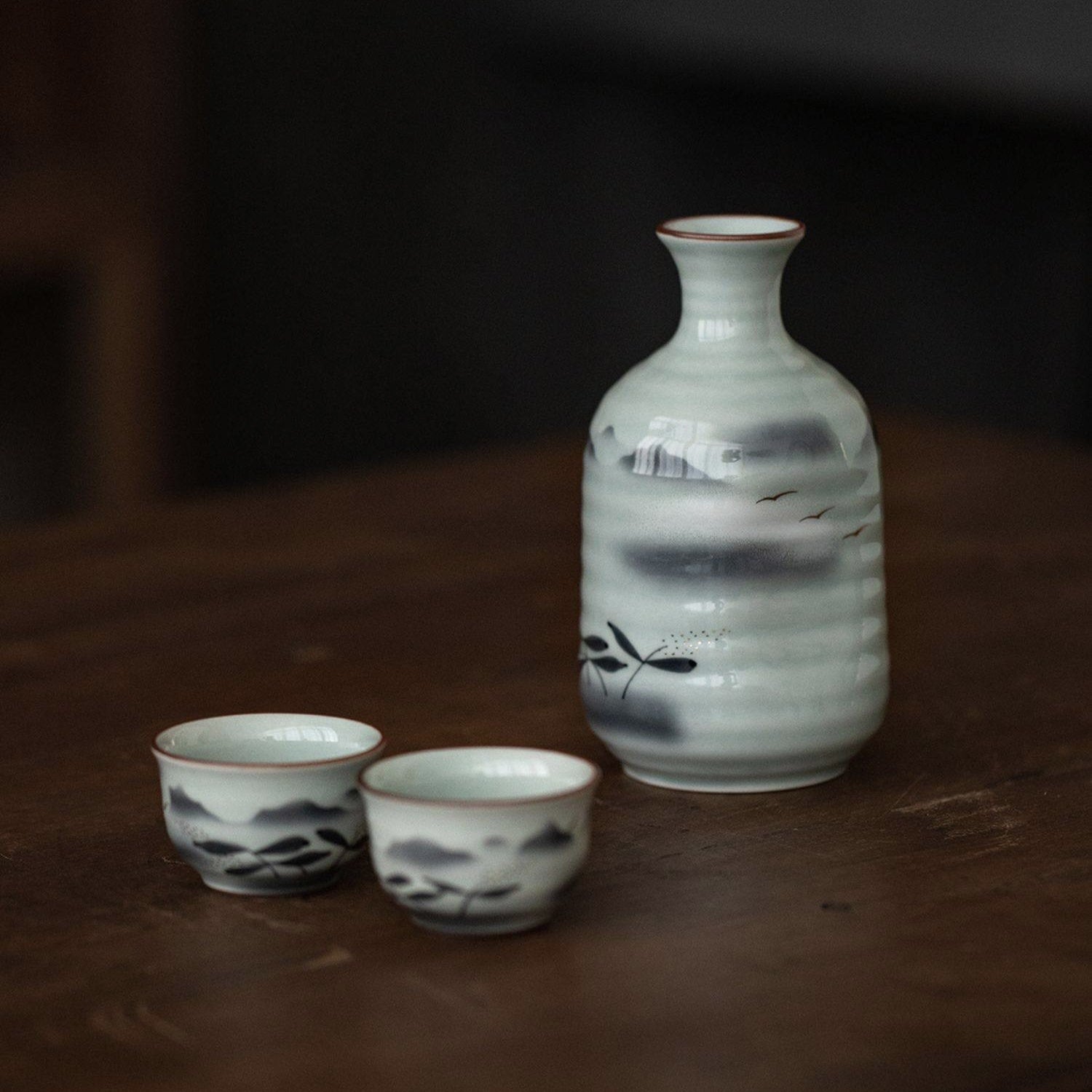 Close-up of hand-painted ceramic cups with mountain-inspired brushstrokes.
